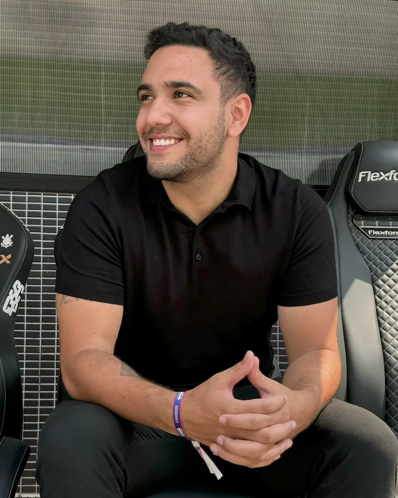 Gustavo, fundador da GMS Sistemas, sorrindo, de camisa polo preta